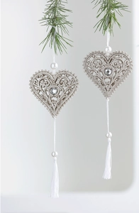 Detailed champagne gold heart snowflake ornament with glitter and white fringe on pine
