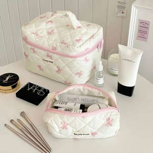 Quilted cream cosmetic bag set with pink bow print for travel toiletries and makeup
