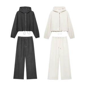 Detail view of hooded zip-up sweatshirt and straight-leg trousers in black and off-white