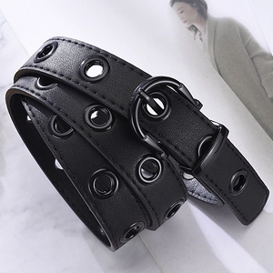 Fashionable black PU leather belt with metal eyelets and buckle on marble background