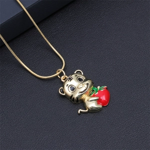 Detailed macro view of a golden tiger pendant with red strawberry and snake chain