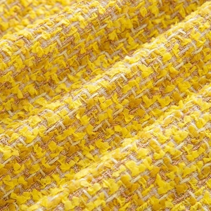Macro shot of bright yellow tweed fabric texture with delicate fringe and premium feather weave