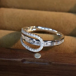 Macro detail of silver ring with baguette-cut zircon stones on brown velvet display