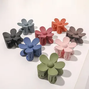 Close-up of matte flower hair claws in multiple candy colors including blue and pink