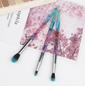 Three-piece eyeshadow brush set with crystal clear handles and blue-black gradient bristles