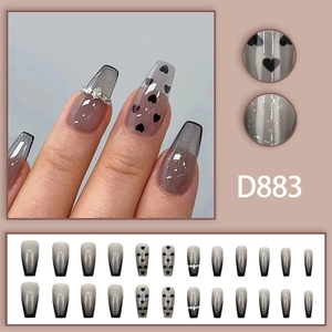 Long coffin press-on nails featuring black gradient heart patterns and rhinestone accents
