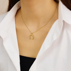 Détail du pendentif fer à cheval plaqué or 18 carats avec zircon sur une chaîne fine