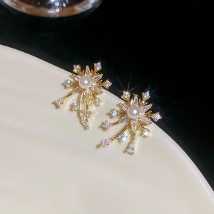 Macro detail of snowflake earrings with white pearl center and sparkling cubic zirconia