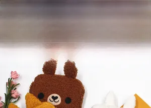 Macro shot of soft plush cartoon animal storage bags in brown bear and white rabbit styles