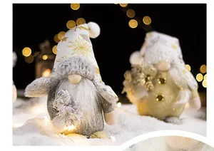 Close-up of Christmas gnomes with golden snowflakes on white hats in festive snow setting