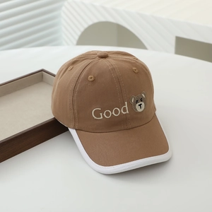 Close-up of khaki cotton kids baseball cap with embroidered bear and Good text