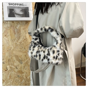 Close-up of plush leopard print crescent bag with circular handle and soft texture