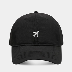 Détail de la broderie d'avion blanc sur une casquette de baseball noire respirante