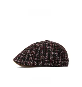 Side view detail of a chic tweed newsboy cap featuring a red and black plaid knit texture