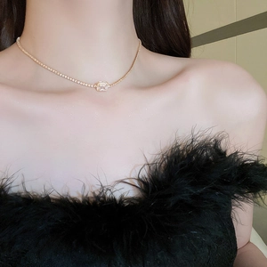 Close-up of elegant gold necklace featuring a square zircon pendant on a model's neck