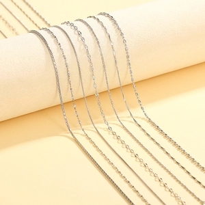 Detail of seven silver minimalist necklaces including box, ball, and snake chains