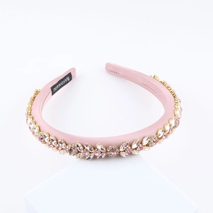Baroque style pink padded headband with colorful crystal rhinestones on a white stand