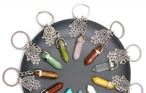 Macro shot of colorful hexagonal crystal pillars with Hand of Fatima keychain pendants
