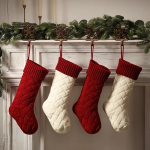 Close-up of four red and white knitted Christmas stockings hanging on a white fireplace mantle
