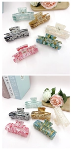 Detailed view of six acrylic hair claws with marble texture in multiple pastel colors