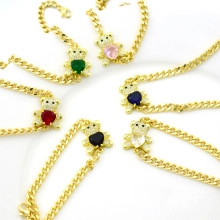Detail of gold Cuban link bracelets featuring teddy bear pendants with multicolor zircons
