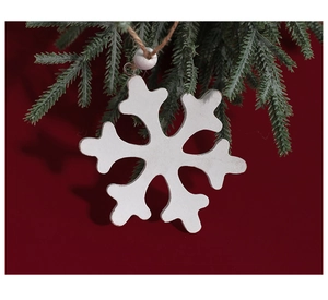 White wooden snowflake ornament with bead hanging on green pine branch with red background
