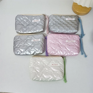 Close-up of quilted PU heart cosmetic bags with metallic finish and colorful woven straps