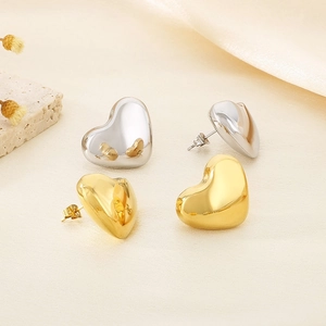 Detailed view of polished heart-shaped earrings in gold and silver stainless steel finish