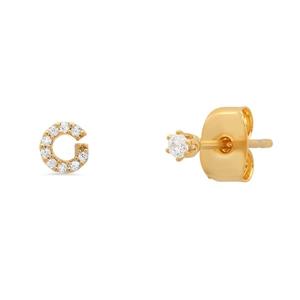 Macro shot of gold S925 sterling silver G letter stud earring with sparkling cubic zirconia