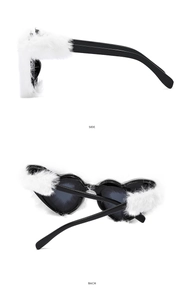 Detail view showing the side and back of plush heart sunglasses with white faux fur trim