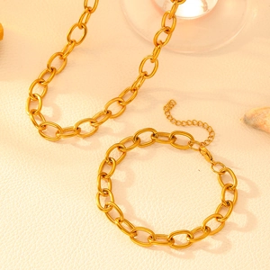 Ensemble collier et bracelet à chaîne en O en acier titane doré sur fond beige texturé