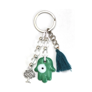 Detail of green Hamsa Hand keychain with Evil Eye motif, silver Tree of Life and teal tassel