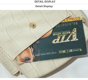 Close-up of beige crocodile pattern leather card holder with a gold snap button