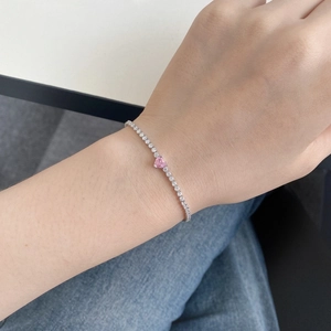 Close-up of S925 silver tennis bracelet with pink heart zircon and sparkling pavé diamonds