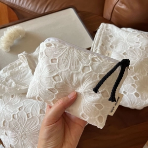 Close-up of white cotton lace embroidery texture and simple wish brand label