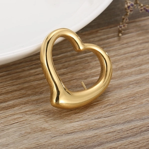 Elegant gold hollow heart-shaped metal pendant necklace charm on a wooden background