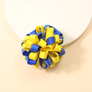 Detailed close-up of blue and yellow ribbed grosgrain ribbon bow on a soft white plate