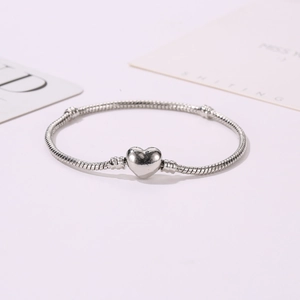 Detailed view of silver heart clasp on snake chain bracelet for DIY bead jewelry