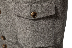 Detail of grey knitted cardigan showing wood-textured buttons and pocket stitching