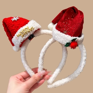 Detail of Christmas headbands with red knit hats, gold glitter stars and white fur trim