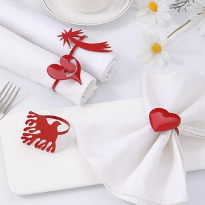Gros plan de ronds de serviette en métal rouge en forme de cœur et d'étoile sur table chic