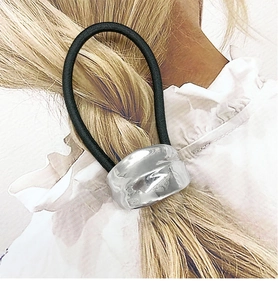 Close-up of minimalist black elastic hair tie with silver irregular liquid metal buckle
