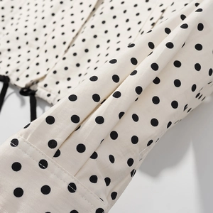 Detailaufnahme der schwarz-weißen Polka-Dot-Stofftextur mit feiner Nahtführung