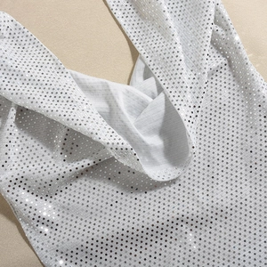 Détail de paillettes argentées et coutures blanches sur la robe dos nu à capuche