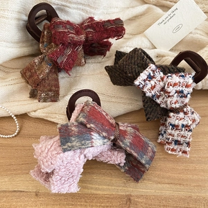 Detailed view of assorted acrylic flocked bow hair claws in tweed and plaid fabrics