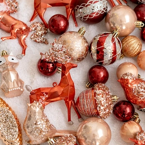 Boules de Noël rouges et dorées avec motifs pailletés sur fond de neige blanche