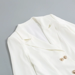 Detailed close-up of white blazer collar featuring luxury gold embossed button accents