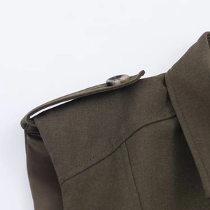 Detailed macro view of military-style shoulder epaulets and buttons on dark brown dress