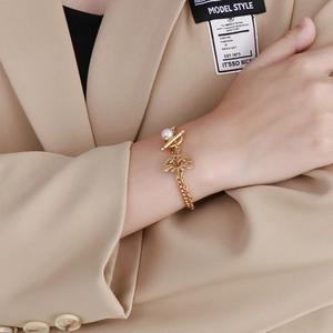 Detail of gold double-layer tree of life bracelet with OT buckle and white pearl charm