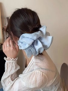 Close-up of light blue chiffon scrunchie with layered ruffle pleats on brown hair